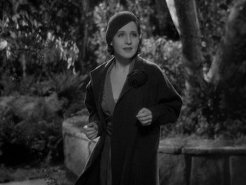 Movie still from “Smilin' Through” (1932), directed by Sidney Franklin – A woman wearing a hat and a coat; Medium shot, High angle