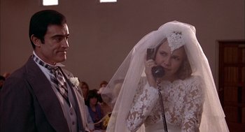Movie still from “Smokey and the Bandit II” (1980), directed by Hal Needham – A man and a woman in wedding attire talking on a phone; Close Up shot, Low angle