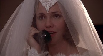 Movie still from “Smokey and the Bandit II” (1980), directed by Hal Needham – A woman in a wedding dress talking on a cell phone; Close Up shot, High angle