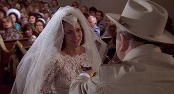 Movie still from “Smokey and the Bandit II” (1980), directed by Hal Needham – A woman wearing a veil is smiling at a man in a hat; Close Up shot, Over the shoulder angle