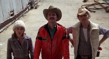 Movie still from “Smokey and the Bandit II” (1980), directed by Hal Needham – A man in a cowboy hat standing next to two other men; Medium shot, Low angle