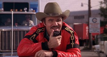 Movie still from “Smokey and the Bandit II” (1980), directed by Hal Needham – A man wearing a cowboy hat while talking on a cell phone; Close Up shot, Low angle