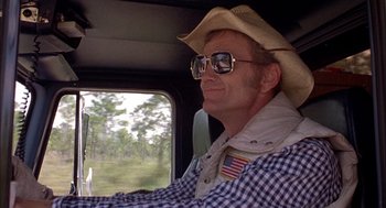 Movie still from “Smokey and the Bandit II” (1980), directed by Hal Needham – A man wearing a cowboy hat driving a truck; Close Up shot, Low angle