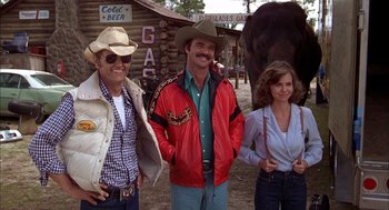 Movie still from “Smokey and the Bandit II” (1980), directed by Hal Needham – Two men and a woman standing next to an elephant; Medium shot, Low angle