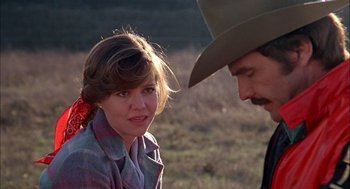 Movie still from “Smokey and the Bandit II” (1980), directed by Hal Needham – A man and a woman are talking in a field; Close Up shot, Over the shoulder angle