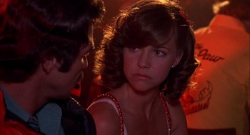 A young woman is looking at a man in a bar