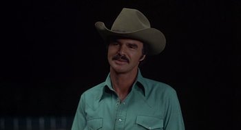 Movie still from “Smokey and the Bandit II” (1980), directed by Hal Needham – A man wearing a cowboy hat and a green shirt; Close Up shot, Over the shoulder angle