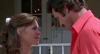 Movie still from “Smokey and the Bandit II” (1980), directed by Hal Needham – A man and a woman looking at each other in front of a building; Close Up shot, Low angle