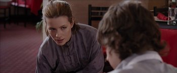 Movie still from “Snow Angels” (2007), directed by David Gordon Green – A woman sitting in front of another woman in front of a table; Close Up shot, Over the shoulder angle