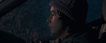 Movie still from “Snow Angels” (2007), directed by David Gordon Green – A person wearing a hat looking to the side; Close Up shot, Low angle
