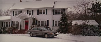 Movie still from “Snow Angels” (2007), directed by David Gordon Green – A car parked in front of a house in the snow; Extreme Wide shot, Low angle