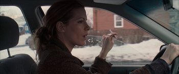 Movie still from “Snow Angels” (2007), directed by David Gordon Green – A woman sitting in a car smoking a cigarette; Close Up shot, Over the shoulder angle