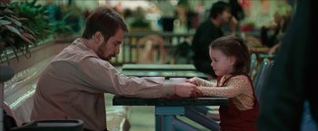 Movie still from “Snow Angels” (2007), directed by David Gordon Green – A man and a little girl at a table with cups; Medium shot, Over the shoulder angle