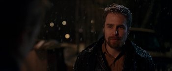 Movie still from “Snow Angels” (2007), directed by David Gordon Green – A man with a beard wearing a jacket and a crown; Close Up shot, Over the shoulder angle