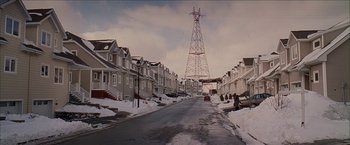 Movie still from “Snow Angels” (2007), directed by David Gordon Green – A street view of houses and a power tower; Extreme Wide shot, Low angle