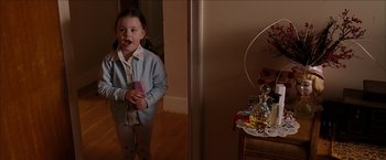 Movie still from “Snow Angels” (2007), directed by David Gordon Green – A little girl standing in front of a mirror holding a wii remote; Medium shot, High angle