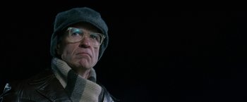 Movie still from “Snow Angels” (2007), directed by David Gordon Green – An older man wearing glasses and wearing a hat; Close Up shot, Low angle