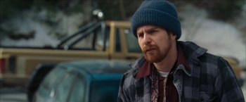Movie still from “Snow Angels” (2007), directed by David Gordon Green – A man wearing a blue hat and a plaid shirt; Close Up shot, Over the shoulder angle