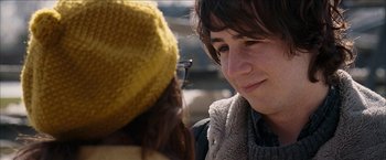 Movie still from “Snow Angels” (2007), directed by David Gordon Green – A woman in a yellow hat and a man in a gray sweater; Close Up shot, Over the shoulder angle