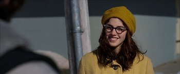 Movie still from “Snow Angels” (2007), directed by David Gordon Green – A woman wearing glasses and wearing a yellow hat; Close Up shot, Over the shoulder angle