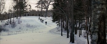 Movie still from “Snow Angels” (2007), directed by David Gordon Green – A group of people walking up a hill in the snow; Extreme Wide shot, High angle