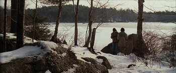 Movie still from “Snow Angels” (2007), directed by David Gordon Green – A group of people standing next to a body of water; Extreme Wide shot, Over the shoulder angle