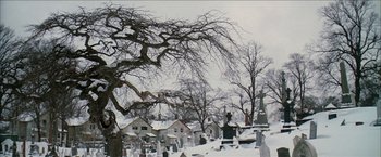 Movie still from “Snow Angels” (2007), directed by David Gordon Green – A cemetery in the snow with a tree in the background; Extreme Wide shot, Low angle