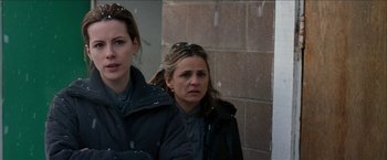 Movie still from “Snow Angels” (2007), directed by David Gordon Green – Two women are standing outside in the snow; Close Up shot, Low angle