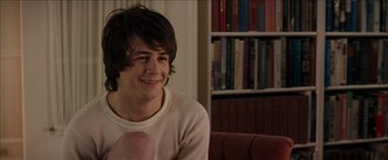 Movie still from “Snow Angels” (2007), directed by David Gordon Green – A man sitting on top of a couch holding a baby; Medium shot, Over the shoulder angle