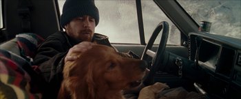 Movie still from “Snow Angels” (2007), directed by David Gordon Green – A man sitting in the drivers seat of a car petting a dog; Close Up shot, Over the shoulder angle