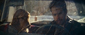 Movie still from “Snow Angels” (2007), directed by David Gordon Green – A man and a woman in a car with trees in the background; Close Up shot, Over the shoulder angle
