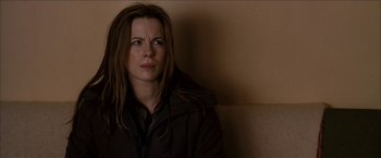 Movie still from “Snow Angels” (2007), directed by David Gordon Green – A person sitting on a couch; Close Up shot, Over the shoulder angle