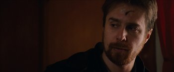 Movie still from “Snow Angels” (2007), directed by David Gordon Green – A man with a goatee is looking at the camera; Close Up shot, Over the shoulder angle