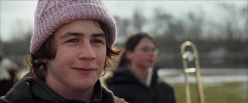 Movie still from “Snow Angels” (2007), directed by David Gordon Green – Two people in a field with trees in the background; Close Up shot, Over the shoulder angle