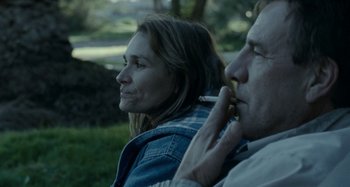 Movie still from “The Snowtown Murders” (2011), directed by Justin Kurzel – A man and a woman sitting next to each other in the grass; Close Up shot, Over the shoulder angle