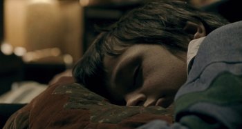 Movie still from “The Snowtown Murders” (2011), directed by Justin Kurzel – A young boy is sleeping on a bed; Close Up shot, Overhead angle