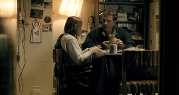 Movie still from “The Snowtown Murders” (2011), directed by Justin Kurzel – A man and a woman are sitting at a table; Medium shot, Over the shoulder angle