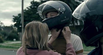Movie still from “The Snowtown Murders” (2011), directed by Justin Kurzel – A woman adjusts a helmet on a man's head; Close Up shot, Over the shoulder angle