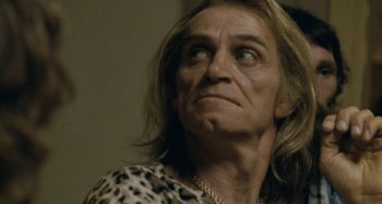 Movie still from “The Snowtown Murders” (2011), directed by Justin Kurzel – An older woman with long blonde hair wearing a leopard print shirt; Close Up shot, Low angle