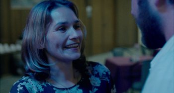 Movie still from “The Snowtown Murders” (2011), directed by Justin Kurzel – A person smiling at the camera; Close Up shot, Over the shoulder angle