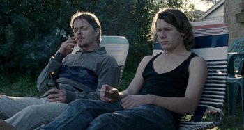 Movie still from “The Snowtown Murders” (2011), directed by Justin Kurzel – A man and a woman sitting next to each other on lawn chairs; Medium shot, Over the shoulder angle