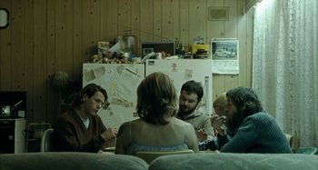 Movie still from “The Snowtown Murders” (2011), directed by Justin Kurzel – A group of people sitting around a table; Medium shot, High angle