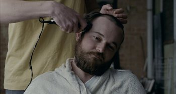 Movie still from “The Snowtown Murders” (2011), directed by Justin Kurzel – A man getting his hair cut by a barber; Close Up shot, Over the shoulder angle