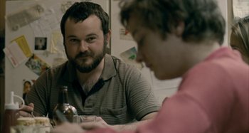 Movie still from “The Snowtown Murders” (2011), directed by Justin Kurzel – A man sitting at a table with a bottle of beer; Close Up shot, Over the shoulder angle