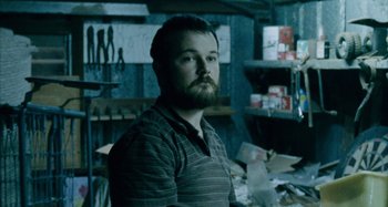 Movie still from “The Snowtown Murders” (2011), directed by Justin Kurzel – A man with a goatee standing in a room; Close Up shot, Over the shoulder angle