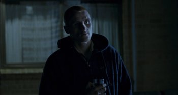 Movie still from “The Snowtown Murders” (2011), directed by Justin Kurzel – A man holding a glass of wine in a dark room; Medium shot, Low angle