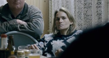 Movie still from “The Snowtown Murders” (2011), directed by Justin Kurzel – A woman sitting at a table with a glass of beer; Close Up shot, Over the shoulder angle
