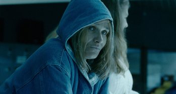 Movie still from “The Snowtown Murders” (2011), directed by Justin Kurzel – A woman in a blue jacket is looking at the camera; Close Up shot, Over the shoulder angle