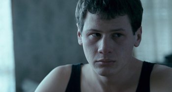 Movie still from “The Snowtown Murders” (2011), directed by Justin Kurzel – A person wearing a tank top; Close Up shot, Over the shoulder angle