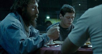 Movie still from “The Snowtown Murders” (2011), directed by Justin Kurzel – Two men sitting at a table eating food; Medium shot, Over the shoulder angle